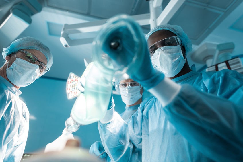 bottom view of african american anesthetist holding oxygen mask above patient